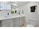 Bright bathroom featuring double vanity, modern fixtures, stylish mirror, and sleek design at 1601 Robb St, Lakewood, CO 80215