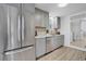 Updated kitchen featuring stainless steel appliances, granite countertops, and gray cabinetry. Access to the laundry room is adjacent at 1601 Robb St, Lakewood, CO 80215
