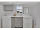 Bright laundry room with white washer, dryer, counter space and gray cabinets at 1601 Robb St, Lakewood, CO 80215