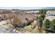 Aerial view of a house with a fenced backyard, patio, and lush greenery near a lake at 1890 Bel Lago Vw, Monument, CO 80132