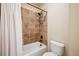 Cozy bathroom featuring a shower-tub combo with brown tiling and storage shelf at 1890 Bel Lago Vw, Monument, CO 80132