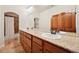 Bathroom featuring double vanity sinks, wood cabinets, granite countertop, and tiled shower at 1890 Bel Lago Vw, Monument, CO 80132