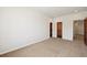 This bedroom features neutral walls and carpet, with wood doors leading to closets at 1890 Bel Lago Vw, Monument, CO 80132