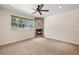 Sunlit bedroom with a stone fireplace, large window with view, and carpeted floor at 1890 Bel Lago Vw, Monument, CO 80132