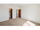 This bedroom features neutral walls and carpet, with wood doors leading to closets at 1890 Bel Lago Vw, Monument, CO 80132