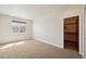 Bright bedroom with neutral carpet, natural light from the window, and closet with dark wood door at 1890 Bel Lago Vw, Monument, CO 80132