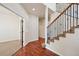 Inviting foyer with hardwood floors, staircase with decorative iron spindles, and doorway leading to another room at 1890 Bel Lago Vw, Monument, CO 80132