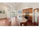 Well-equipped kitchen featuring an island with a sink, wooden cabinetry, stainless steel appliances, and wood floors at 1890 Bel Lago Vw, Monument, CO 80132