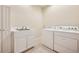 Functional laundry room with white appliances, tile flooring, sink, and ample counter space for folding at 1890 Bel Lago Vw, Monument, CO 80132