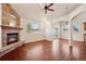 Open living room with a stone fireplace, hardwood floors, and abundant natural light at 1890 Bel Lago Vw, Monument, CO 80132