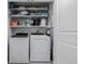 Laundry room with washer, dryer, shelving, and cleaning supplies at 1700 Bassett St # 513, Denver, CO 80202