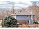 Two-story blue house featuring a gray roof, brick foundation, manicured landscaping, and mountain views at 2208 S Eldridge Ct, Lakewood, CO 80228