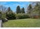Lush green backyard featuring a well-maintained lawn, mature trees, and beautiful landscaping at 5880 S Happy Canyon Dr, Cherry Hills Village, CO 80111