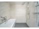 Modern bathroom with a soaking tub, shower, marble walls, and updated fixtures at 5880 S Happy Canyon Dr, Cherry Hills Village, CO 80111