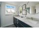 Bathroom featuring a dual vanity with marble countertops, sleek mirrors, and modern fixtures at 5880 S Happy Canyon Dr, Cherry Hills Village, CO 80111