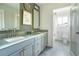 Bathroom featuring a double vanity with marble countertops, gray cabinets, and gold hardware at 5880 S Happy Canyon Dr, Cherry Hills Village, CO 80111