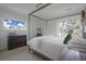 Bright bedroom featuring a canopy bed, vintage dresser, and bright windows with outdoor views at 5880 S Happy Canyon Dr, Cherry Hills Village, CO 80111