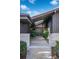 Inviting front entrance featuring a skylight, modern double doors, stone accents, and lush landscaping at 5880 S Happy Canyon Dr, Cherry Hills Village, CO 80111