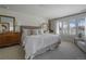 Bright main bedroom with large windows, a plush bed, and a lovely view of the yard at 5880 S Happy Canyon Dr, Cherry Hills Village, CO 80111