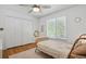 Cozy bedroom with hardwood floors, ceiling fan, and large window at 10291 Carrara Ter, Parker, CO 80134
