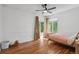 Bright bedroom with hardwood floors, a ceiling fan, and large windows overlooking the yard at 10291 Carrara Ter, Parker, CO 80134