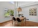 Cozy dining area with hardwood floors, modern lighting, and scenic view of the outdoors in a well-lit room at 10291 Carrara Ter, Parker, CO 80134