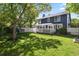 Exterior view of home showcasing the backyard, deck and a large tree at 10291 Carrara Ter, Parker, CO 80134