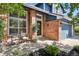 Inviting front porch with brick facade, chairs and an elegant front door in a charming curb appeal setting at 10291 Carrara Ter, Parker, CO 80134