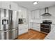 Bright kitchen with stainless steel refrigerator, white cabinetry, granite counters, and tile backsplash at 10291 Carrara Ter, Parker, CO 80134