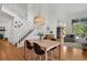 Open-concept living room with hardwood floors, a dining area, and an inviting staircase leading to the upper level at 10291 Carrara Ter, Parker, CO 80134