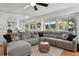 Cozy living room with sectional sofa, ceiling fan, and view to outdoor pergola covered patio at 10291 Carrara Ter, Parker, CO 80134