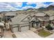 Stunning home featuring a three-car garage and stone accents, set against a scenic mountain backdrop at 15784 Burrowing Owl Ct, Morrison, CO 80465