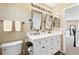 Elegant bathroom with double sinks, stylish mirrors, modern lighting, and wood flooring at 8196 Wetherill Cir, Castle Pines, CO 80108