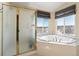Bright bathroom showcasing a glass-enclosed shower, a large soaking tub, and a view of the neighborhood at 8196 Wetherill Cir, Castle Pines, CO 80108