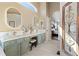 Bright and airy bathroom featuring double sinks, custom cabinets, an oval mirror, and stylish decor at 8196 Wetherill Cir, Castle Pines, CO 80108