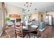 Open-concept dining room with hardwood floors, a round wood table, and views of the living room and staircase at 8196 Wetherill Cir, Castle Pines, CO 80108