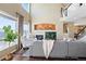 A living room with a fireplace, large windows, comfortable seating, and access to the staircase, offering a cozy atmosphere at 8196 Wetherill Cir, Castle Pines, CO 80108