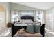 Bright main bedroom with a dark wood bed frame, decorative pillows, and soft natural light from large windows at 8196 Wetherill Cir, Castle Pines, CO 80108