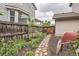 Fenced backyard with stone walkway, lush plants, and a tranquil ambiance at 8317 Liverpool Cir, Littleton, CO 80125