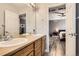 Bathroom with a double sink vanity, wooden cabinets, and view to another bedroom at 8317 Liverpool Cir, Littleton, CO 80125