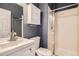Modern bathroom featuring a white vanity, toilet, mirror, and glass-enclosed shower at 8317 Liverpool Cir, Littleton, CO 80125