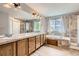 Expansive bathroom with double sinks, bathtub, and separate shower with tile flooring at 8317 Liverpool Cir, Littleton, CO 80125