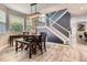 Inviting dining area with a wooden table, modern light fixture, and view of the staircase at 8317 Liverpool Cir, Littleton, CO 80125