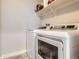 Bright laundry area with a modern washer and dryer set and convenient overhead shelving at 8317 Liverpool Cir, Littleton, CO 80125