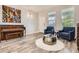 Bright living room with a piano, hardwood floors, modern furnishings, and ample natural light at 8317 Liverpool Cir, Littleton, CO 80125