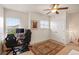 Bright bedroom with two windows, a ceiling fan, and two gaming chairs at 5800 Tower Rd # 610, Denver, CO 80249