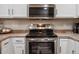 Modern kitchen features stainless steel appliances, sleek microwave and stove top, and white cabinets at 5800 Tower Rd # 610, Denver, CO 80249