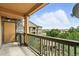 Outdoor balcony featuring wooden railing and exterior stone with distant building views at 8489 Canyon Rim Cir # 302, Englewood, CO 80112