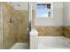 Bright bathroom showcasing a tiled shower, luxurious soaking tub, and a window for natural light and ventilation at 8489 Canyon Rim Cir # 302, Englewood, CO 80112