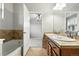 Bathroom featuring a bathtub and dual sink vanity with an open doorway revealing a view into the bedroom at 8489 Canyon Rim Cir # 302, Englewood, CO 80112